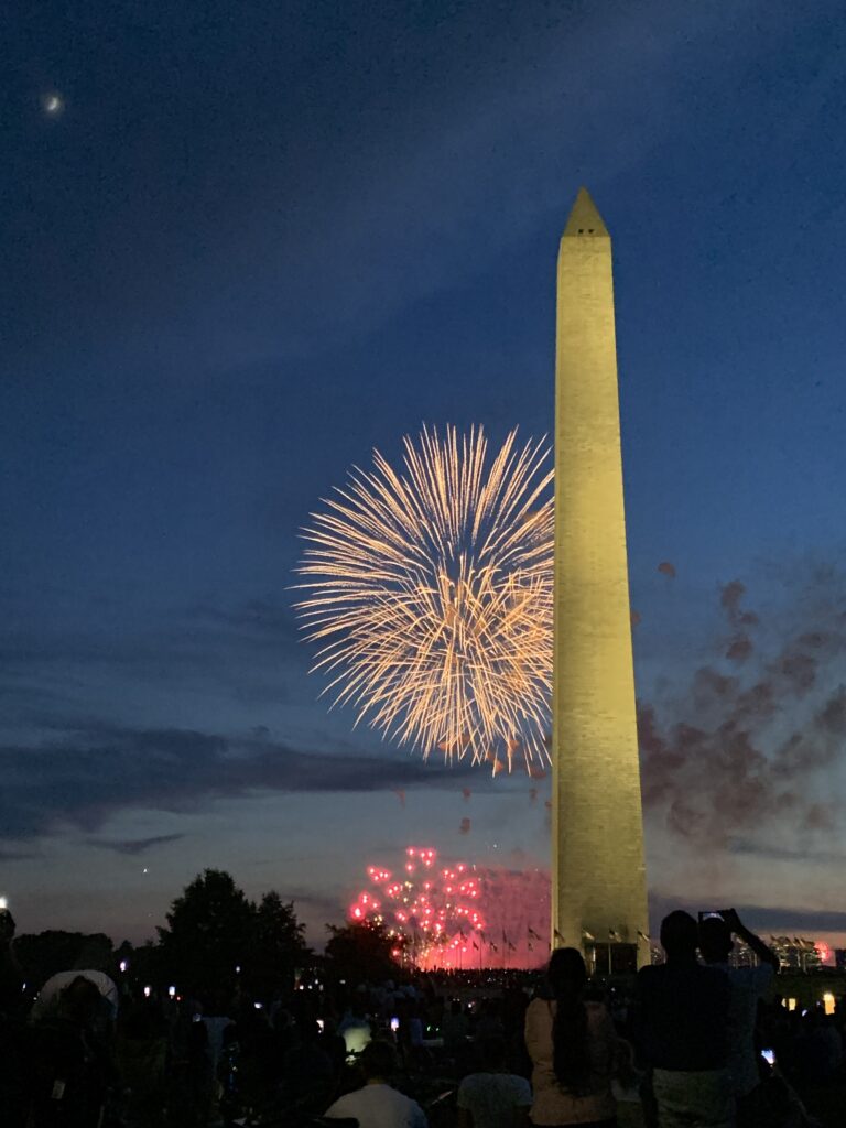 Photo of the National Monument with fireworks behind it on the Fourth of July
