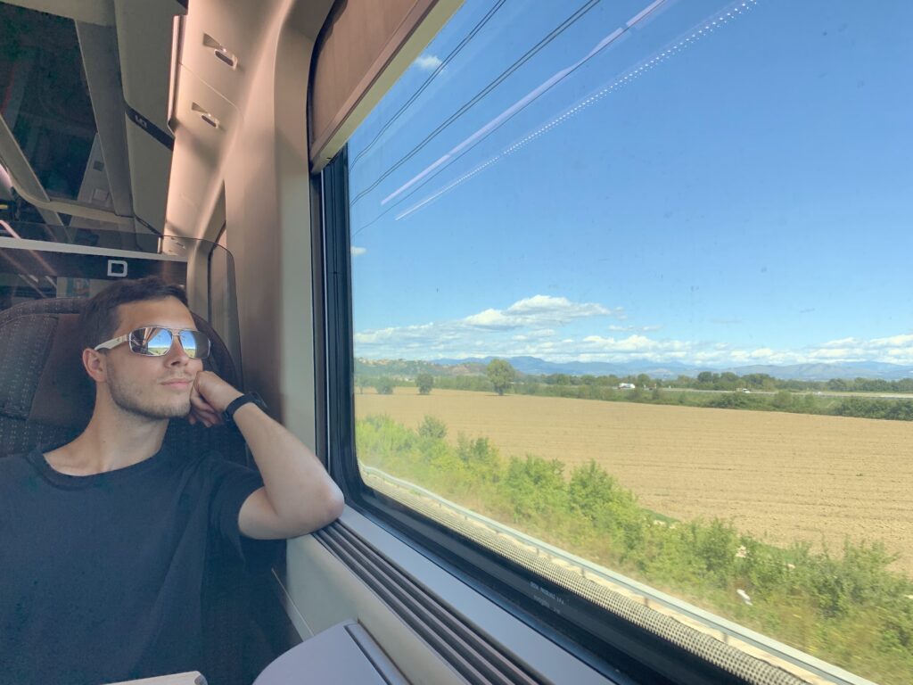 Dylan on a train looking out at the beautiful European scenery
